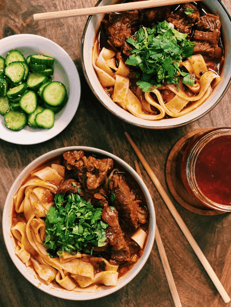 Two bowls of Authentic Taiwanese Beef Noodle Soup made with beef shank topped with chopped green onions