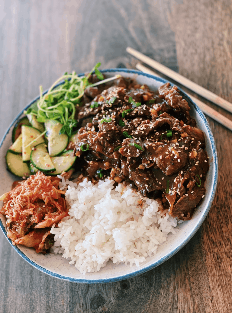 Spicy Beef Bulgogi (Spicy Bulgogi) Bowl with Bulgogi, kimchi, and pickled cucumbers on rice