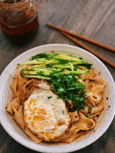 10 Minutes Spicy Garlic Noodle with sliced cucumbers, fried egg, and chopped green onions