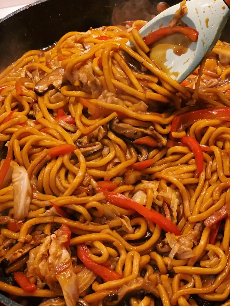 Adding Sauce into sauteed noodles and vegetables for Vegetarian Shanghai Noodles 
