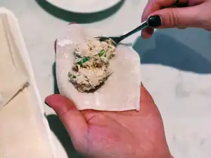 Adding creamy crab cheese filling into wonton wrappers for crab rangoon