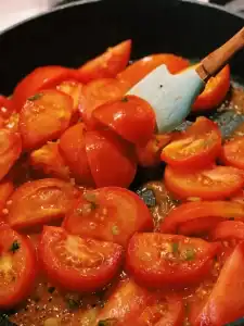 Tomato sliced in quarters sauteed in a pan to make Tomato and Egg Stir-Fry