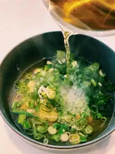 Pouring hot oil into scallion oil paste for Taiwanese Scallion Pancakes