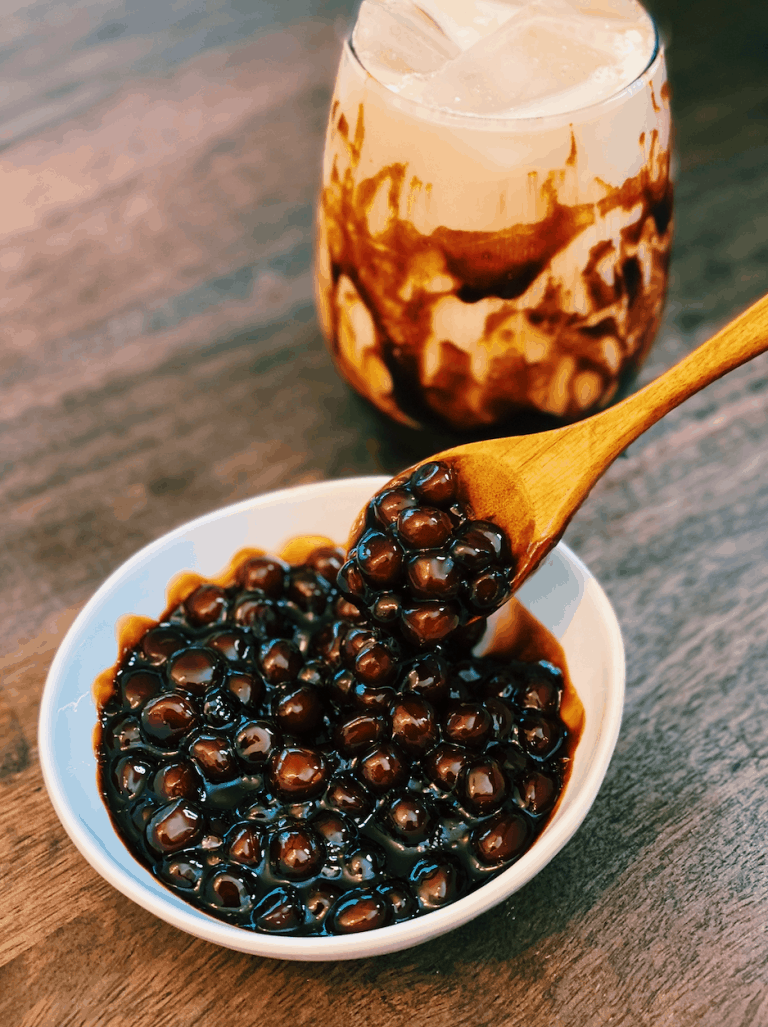 Freshly cooked Brown Sugar Boba with a glass of brown sugar milk in the background.