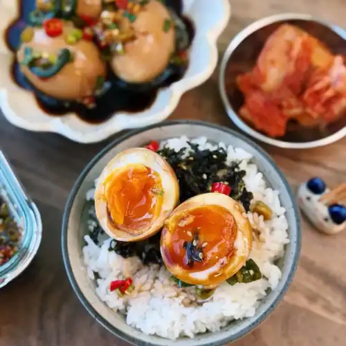 Korean Soy Marinated Eggs, or Mayak Gyeran, sliced and served on top of hot rice.