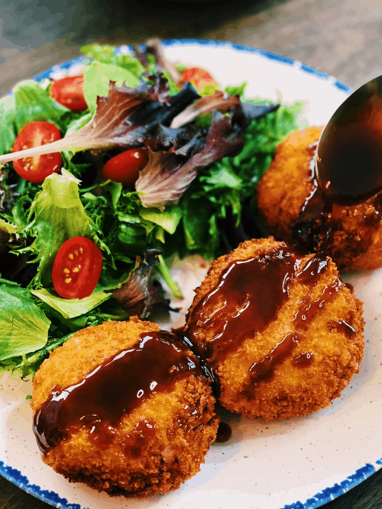 A photo of Cheesy Japanese Potato Croquette (Korokke), crispy on the outside and soft inside, showcasing a delicious vegetarian Asian dish.