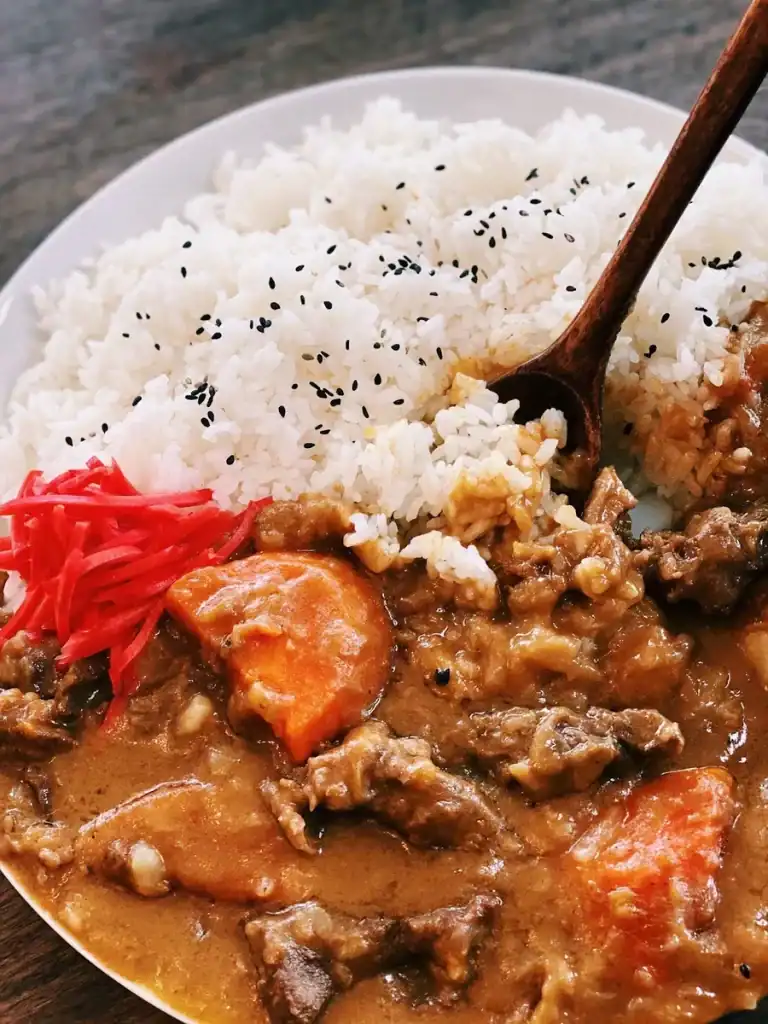 Scooping up rice and beef curry from a plate of Japanese Beef Curry