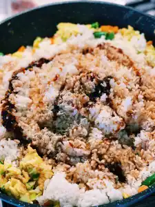 Adding seasoning and cold rice to pan for easy egg fried rice