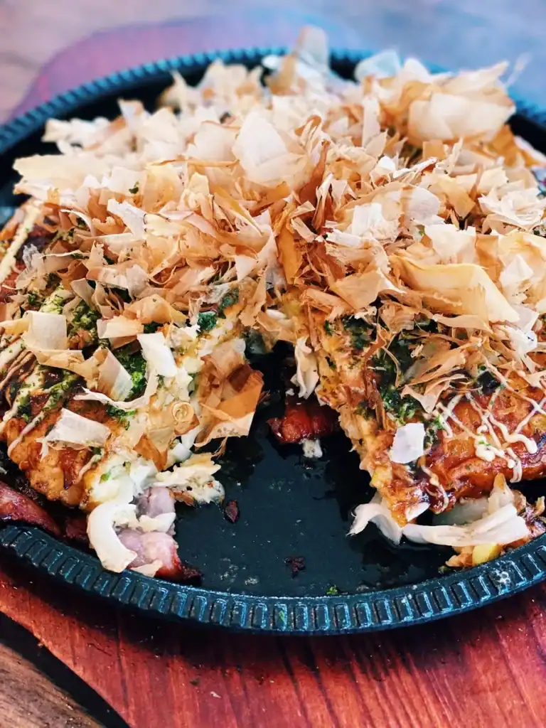 Okonomiyaki sliced, showing a cross section with all the toppings

