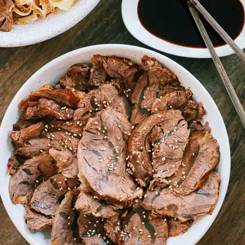 Sliced Taiwanese Beef Shank on a plate served with dipping sauce