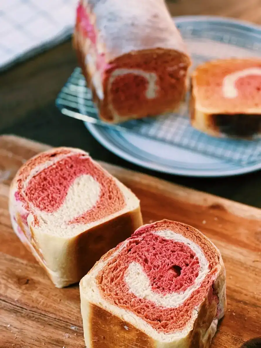 Slices of freshly baked Beetroot Milk Bread, with swirls of pink and white at the center
