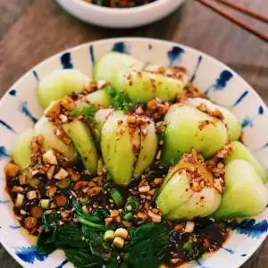 Spicy Garlic Bok Choy Served on a plate drizzled with spicy garlic sauce