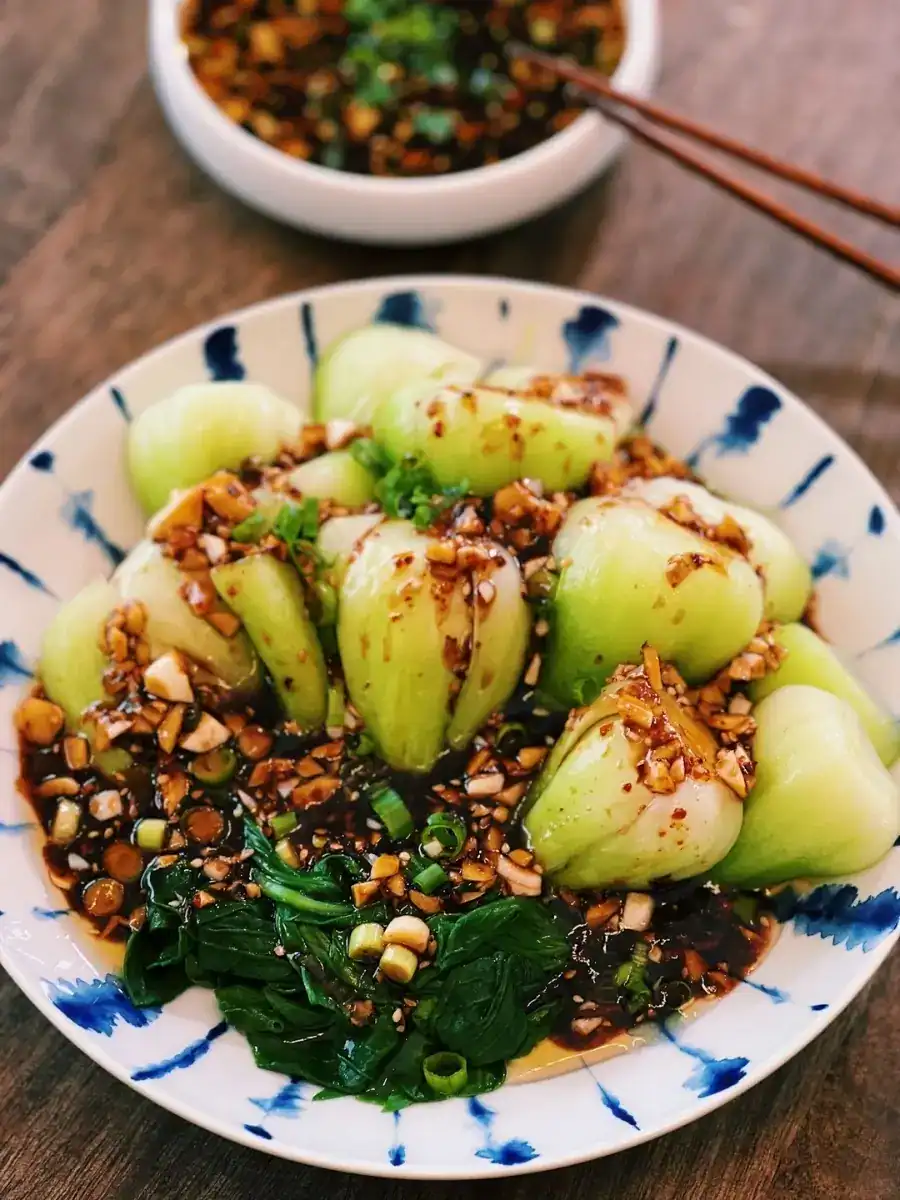 Spicy Garlic Bok Choy Served on a plate drizzled with spicy garlic sauce