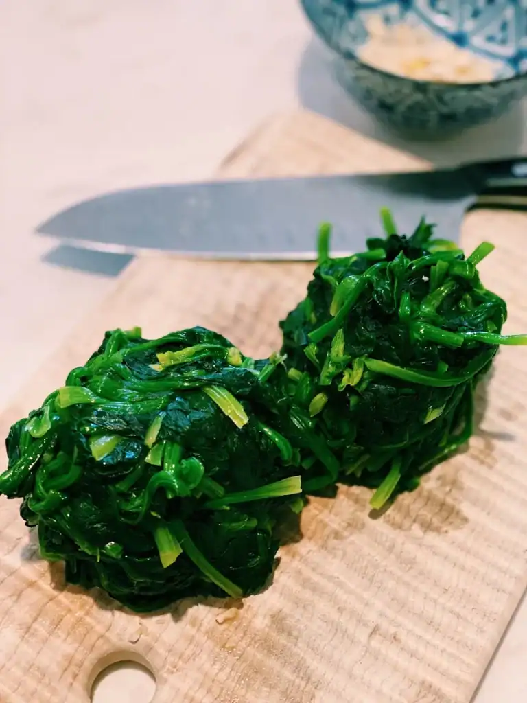 Squeezing water out of cooked spinach for Korean Spinach Banchan