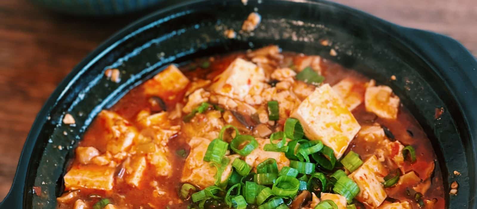 Vegetarian Mapo Tofu Served in a clay pot with a bowl of rice
