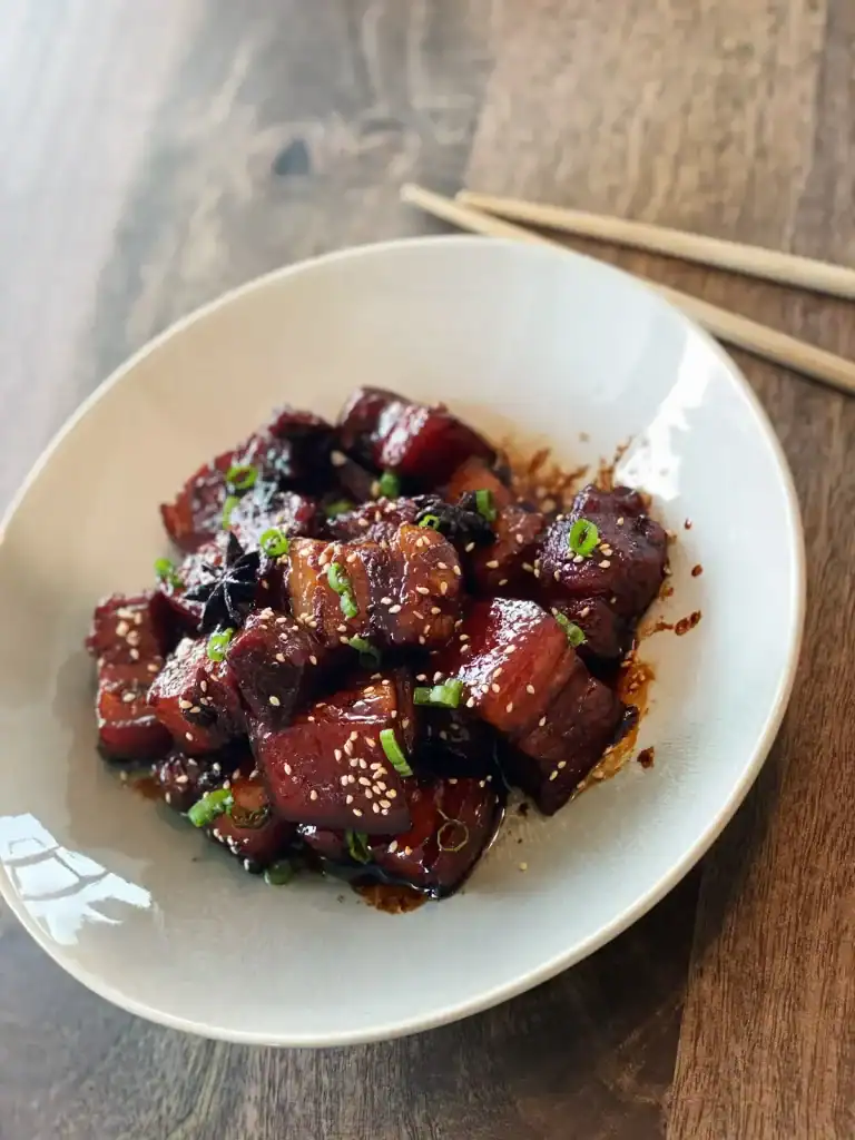 A Bowl of Sticky Pork Belly with chopsticks
