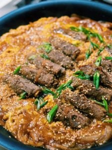 Enoki Beef Roll simmering in sauce for Enoki Beef Rice Bowl