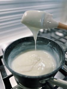 The correct consistency for milk pudding, a chewy milk dessert, is a thick consistency where the pudding slowly drips off the spatula.