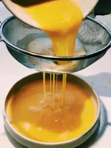 Straining beaten egg in order to remove extra bubbles on Chinese Steamed Eggs