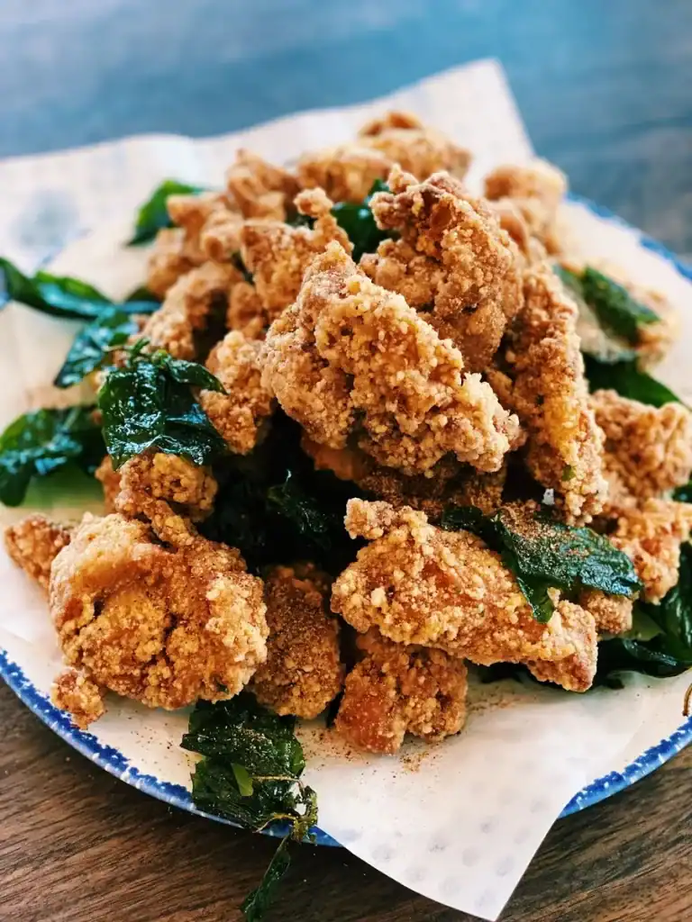 A plate full of Taiwanese Fried Chicken with fried basil