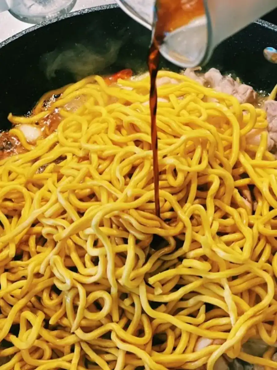 Adding Noodles and Sauce into the pan for Taiwanese 3 Cup Chicken Noodle Stir Fry
