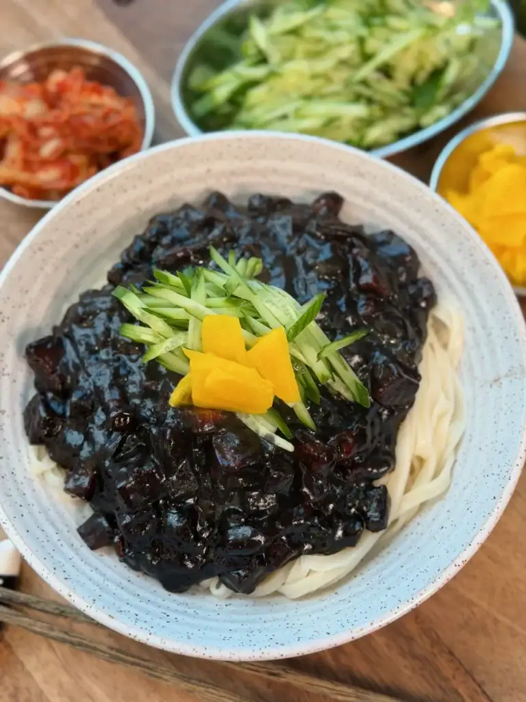 Korean Black Bean Sauce Noodles Served with sliced cucumbers and pickled radish