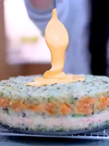 Adding Spicy Mayo on top of Mayo Crab Spicy Salmon Sushi Cake
