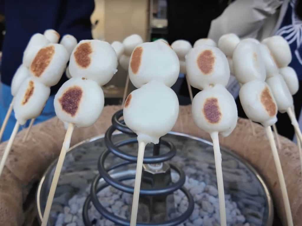 a circle of rice cake skewers grilling over a grill in Asakusa sensoji's street food area, Nakamise-dori 
