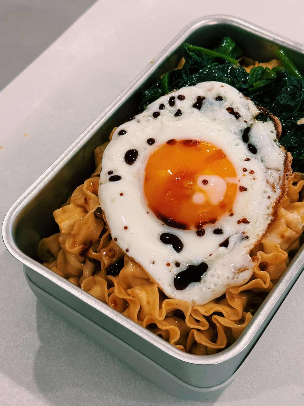 hearty lunchboxes packed with 10 minute thick saucy noodles, a korean blanched spinach salad, and topped with a perfectly fried egg drizzled with some soy sauce