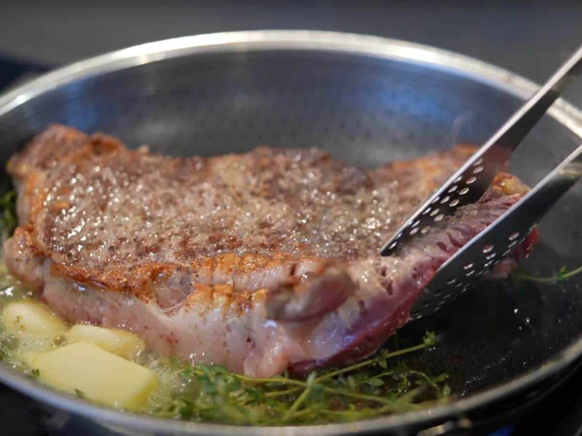Dom cooks a wonderfully seared steak for date night with fresh herbs, garlic, and butter