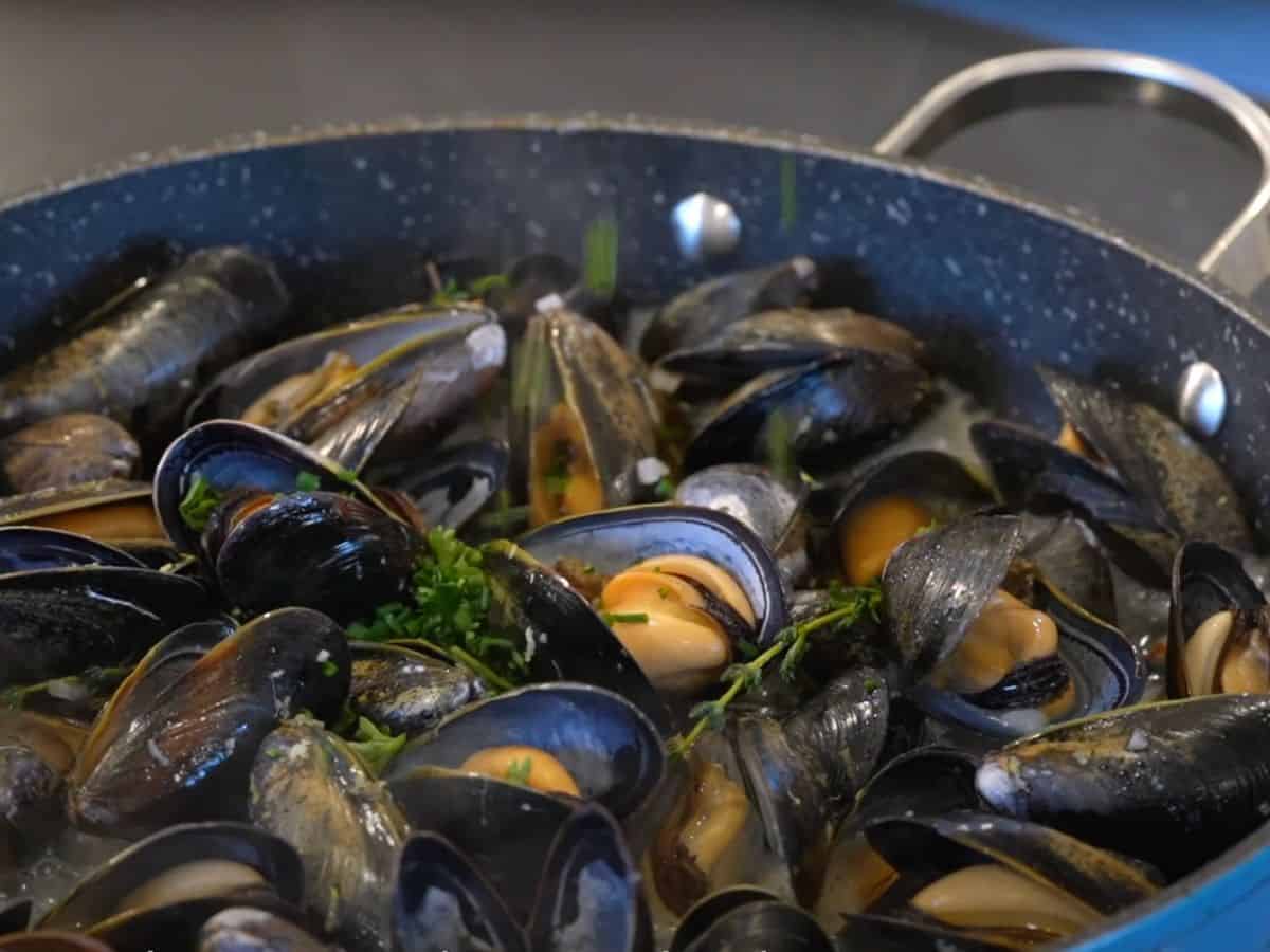 A pan full of mussels flavored with butter and herbs, perfect for date night 