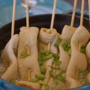A pot full of Korean Fish Cake Skewer Soup garnished with chopped green onions