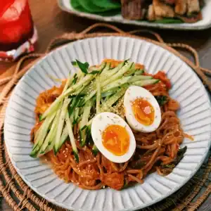 Korean Spicy Cold Noodles served with cucumbers and soft boiled eggs
