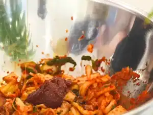 Mixing Kimchi and various seasoning to make Bibim Guksu or Spicy Korean Cold Noodles recipe great for Summer!