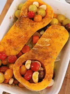 Spicing and Oiling Butternut squash, tomatoes, and garlic for roasting to add to Dairy-Free Butternut Squash Pasta into the pan