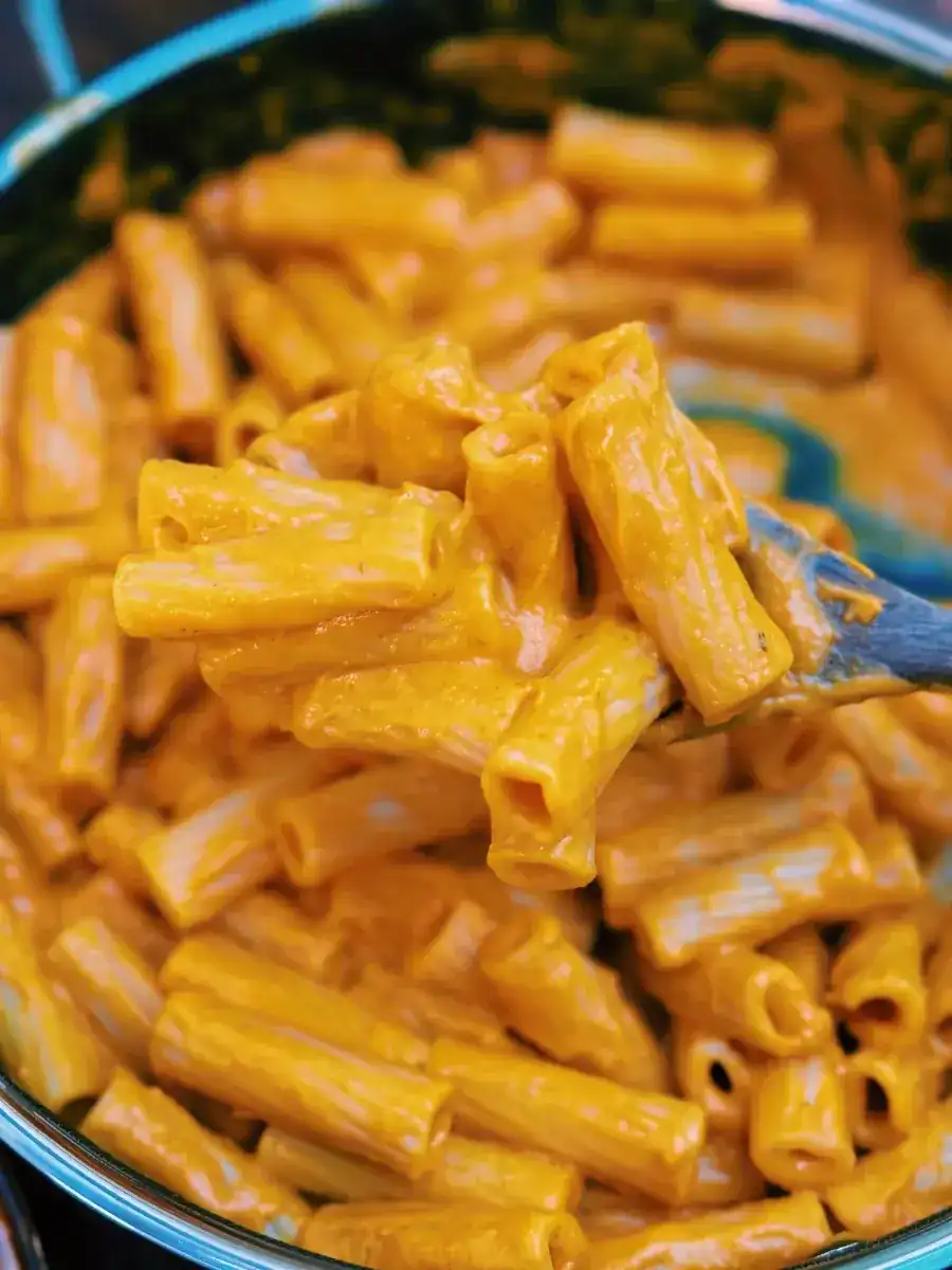 Mixing sauce and pasta for Dairy-Free Butternut Squash Pasta into the pan