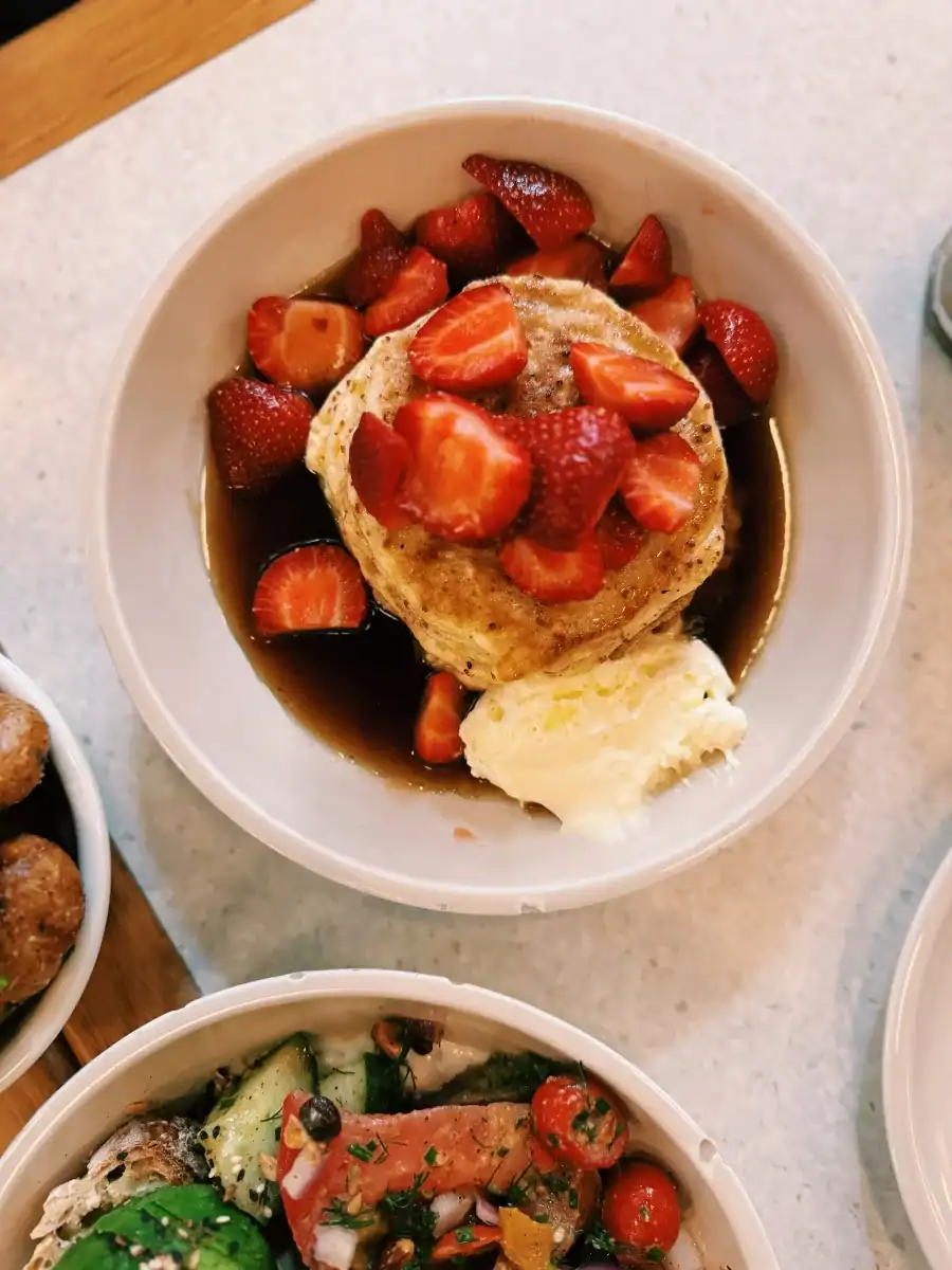 Ricotta Pancakes ($19.99) with maple brown butter sauce and lemon cream covered in fresh strawberries at Dandy in Old Montreal