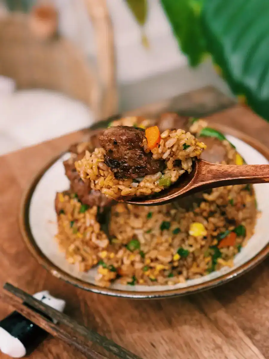 Black Pepper Steak Fried Rice Served in a plate, with a spoonful lifted towards the viewer.