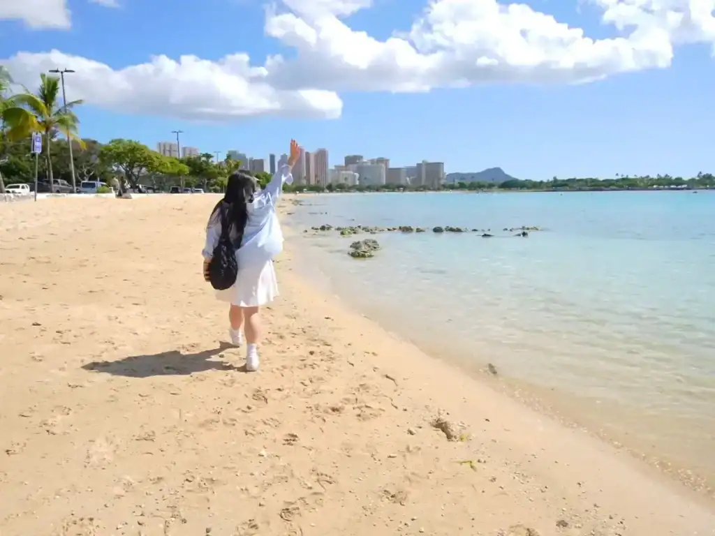 Tiffy Visiting Ala Moana Beach in Honolulu, Oahu, which has white sands, blue skys, and super clear water in Hawaii