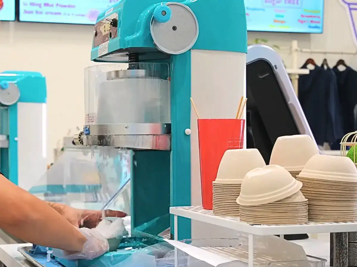Employee making shave ice at Ululani's Gourmet Hawaiian Shave Ice