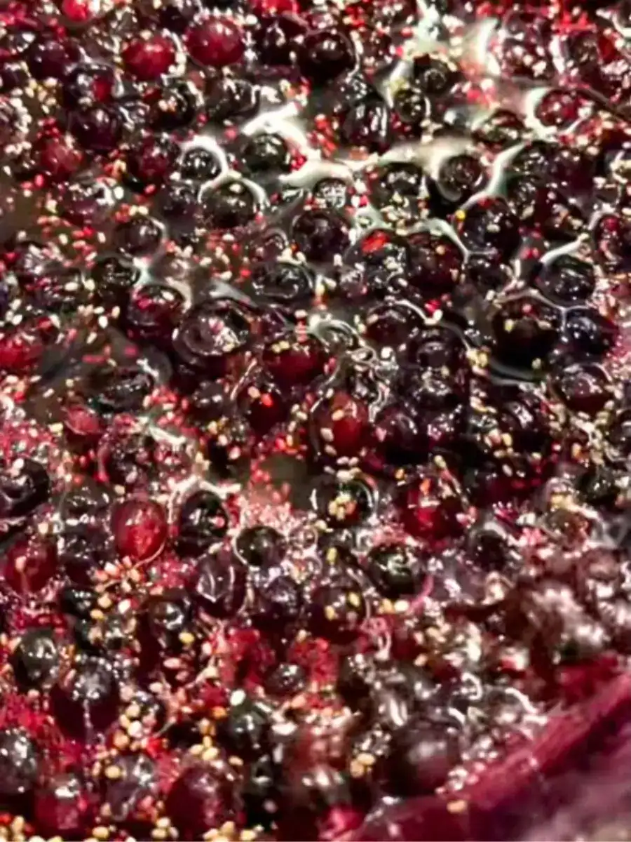 Simmering blueberries and chia seeds for healthy fizzy Blueberry Chia Drink