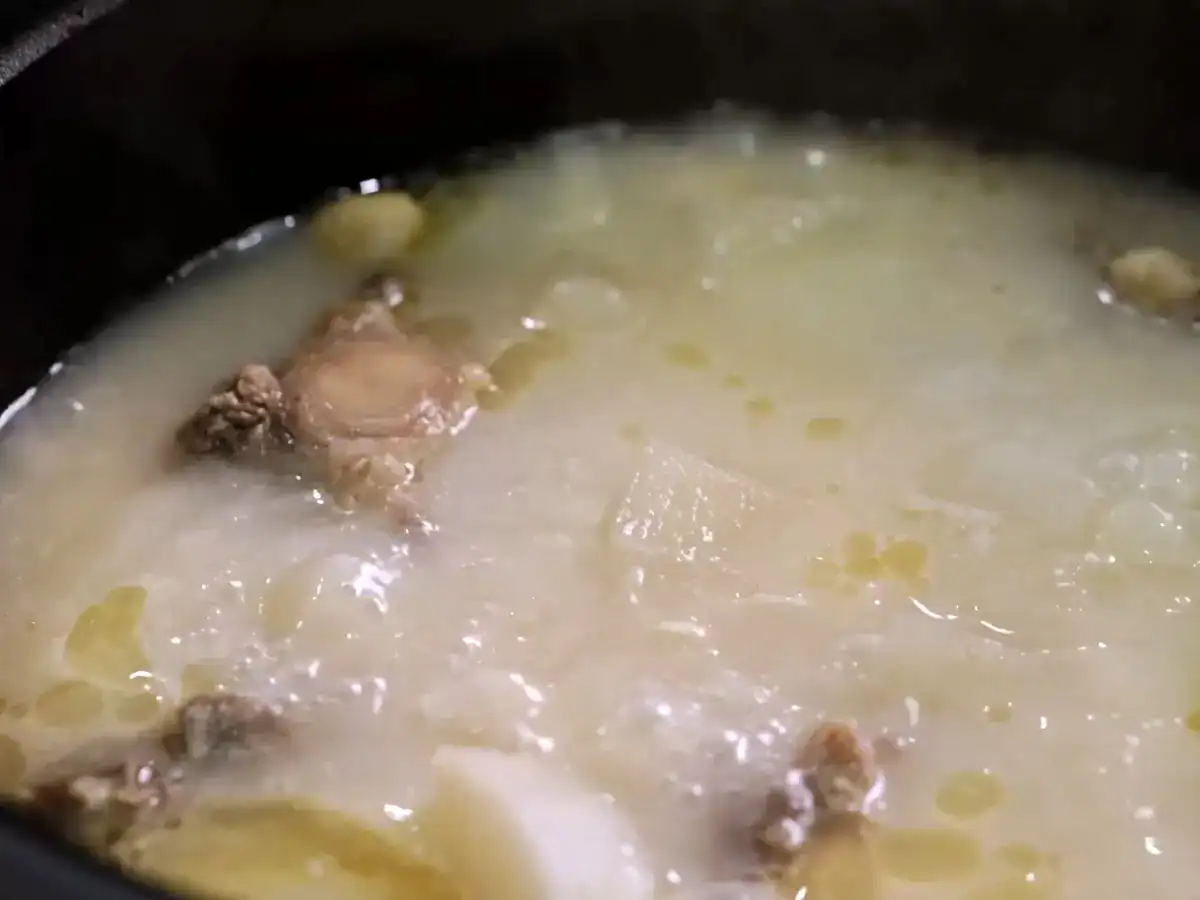 Skimming fat off of Korean Oxtail Soup made with bone broth