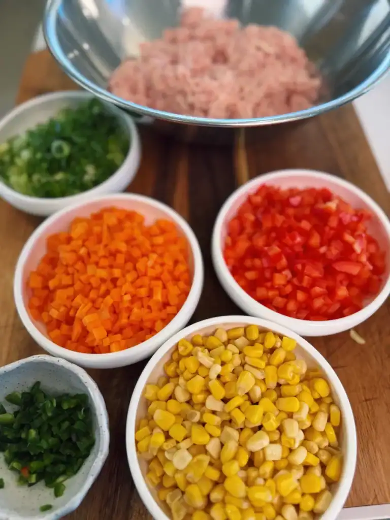 Chopped vegetables mixed into Spicy Chicken Veggie Patties