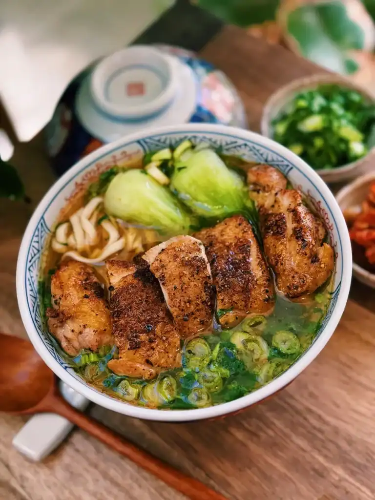 Crispy Chicken Thigh over Noodle Soup with bok choy and green onions 