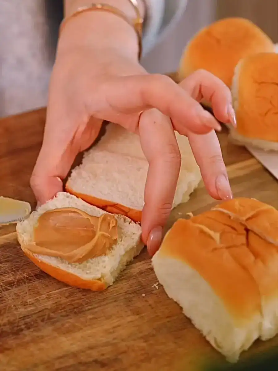 Spreading peanut butter on slices of Hawaiian Sweet Rolls for Hong Kong Style Mini French Toast. 