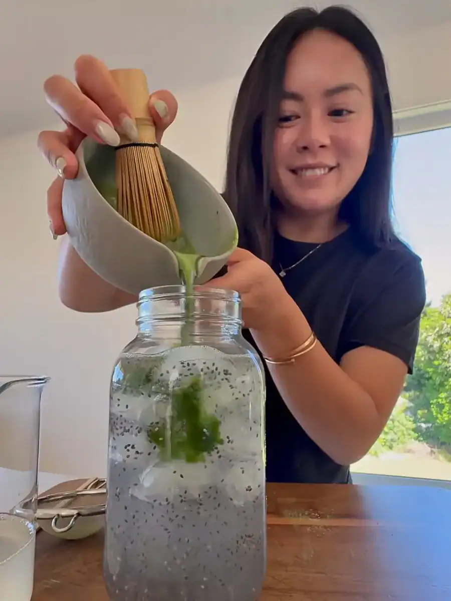 Pouring whisked matcha into lemonade and soaked chia seed for matcha chia lemonade 
