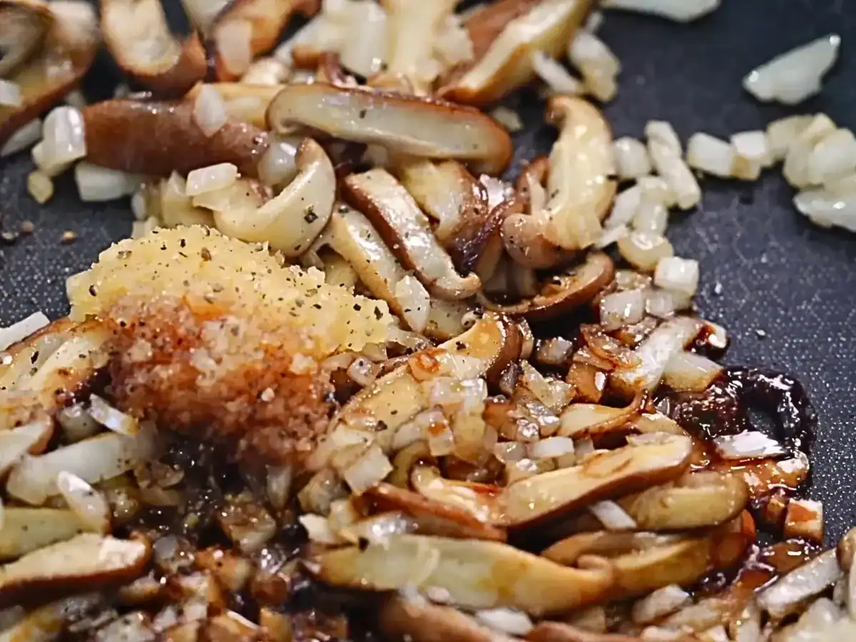Adding garlic, soy sauce, and black pepper to sautéed mushrooms and onions to make the base for Mushroom Gnocchi