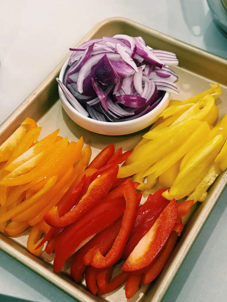 An array of colorful bell peppers and purple onions for One Pot Jumbo Prawn Coconut Curry 