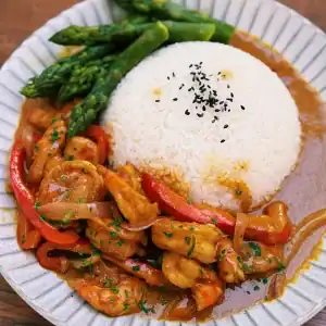 One Pot Jumbo Prawn Coconut Curry served on a plate with veggies and rice