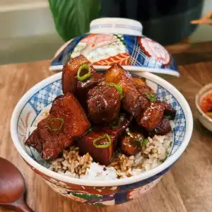 Scallion Soy Braised Pork Belly Served on top of Rice in a bowl